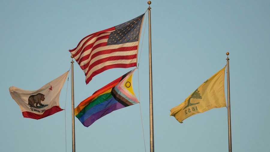 Image: A Pride flag flies under a flag of the United States at Oakland Alameda Coliseum in Oakland,...