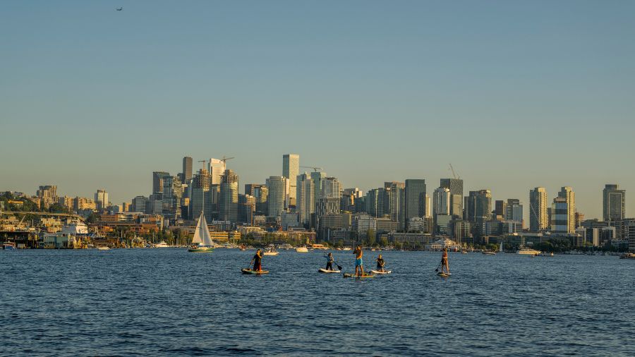 People paddle boarding on Lake Union with the Seattle skyline in background, Seattle, Washington St...